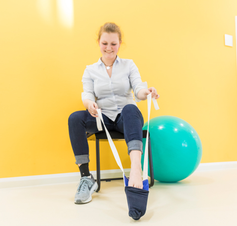 Ergotherapie: Bewegungstraining, um Socken selbstständig anzuziehen