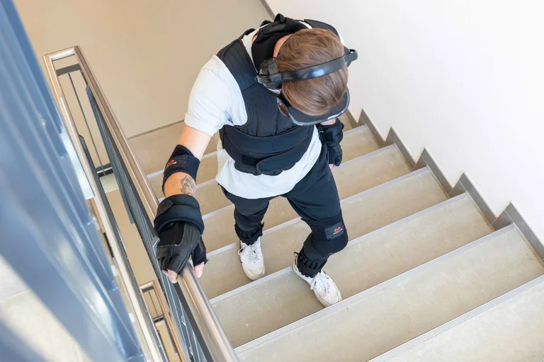 Pflegekraft Tim Böcker beim Treppensteigen