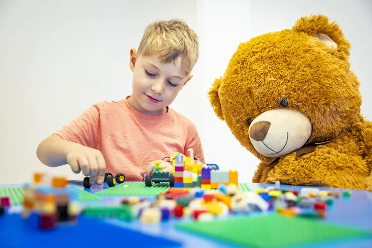 Ein Kind spielt am Tisch mit Legos