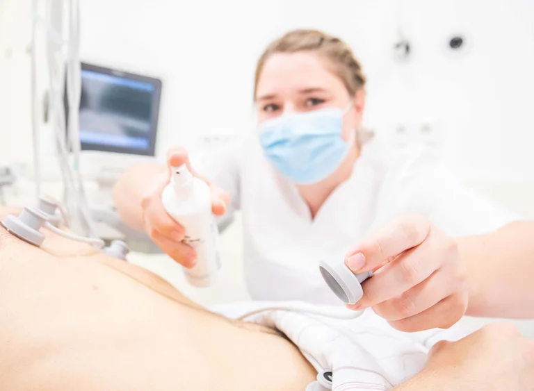 Damit die Messung gelingt, bringt die stellvertretende Stationsleitung insgesamt 10 Elektroden auf dem Körper des Patienten an.