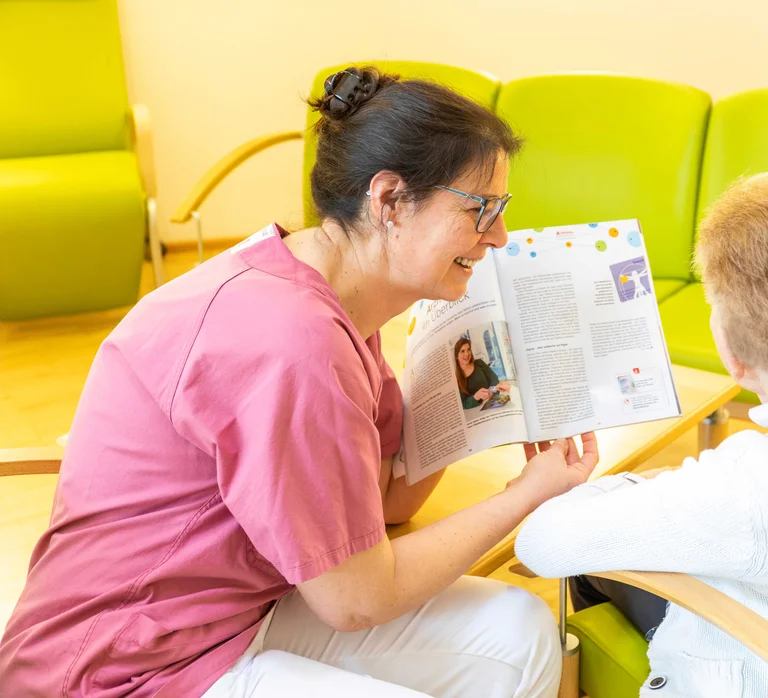 Demenzbeauftragte Claudia Wagner liest eine Zeitschrift mit einer Seniorin