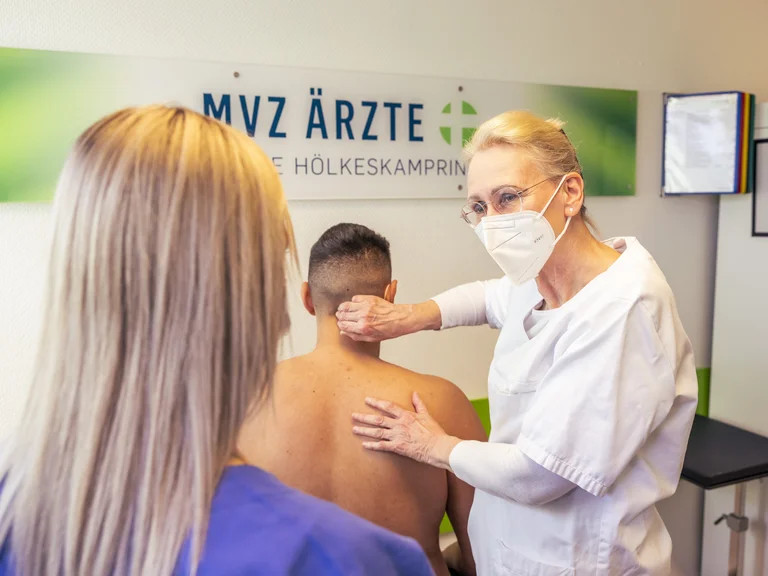 Eine Ärztin erklärt einer Assistenzärztin etwas anhand eines Patienten