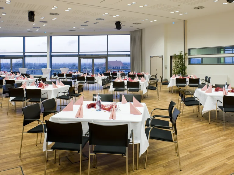 Kongresszentrum - Veranstaltungsraum mit eingedeckten Tischen