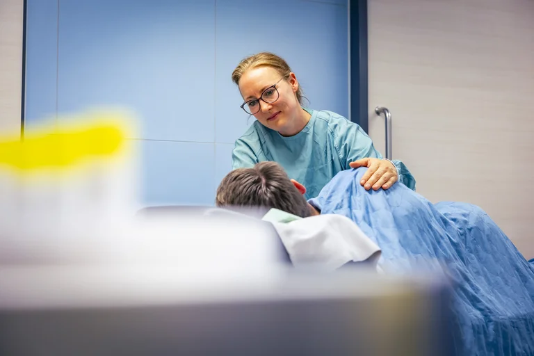 Endoskopiepflegerin beruhigt einen Patienten vor dem endoskopischen Eingriff
