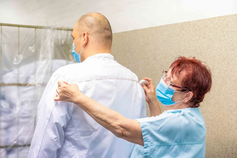 Zu der Arbeit in der Warenannahme von Heidi Grams gehört auch das Vermessen von Kitteln.