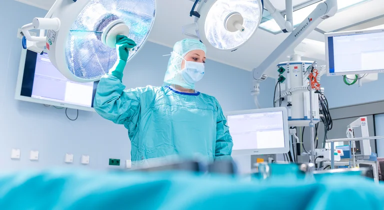 Eine Pflegekraft im Operationsdienst am OP-Tisch