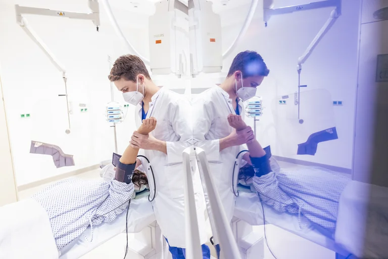 Ein assistenzarzt Innere Medizin misst den Blutdruck