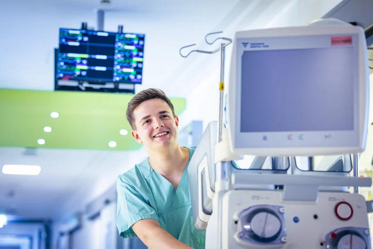 Nico Bratkowiak schiebt im Rahmen seines Praktikums ein medizinisches Gerät über den Flur des Krankenhauses.