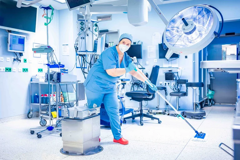 Im OP-Saal müssen die Reinigungskraft und ihr Team alle Oberflächen gründlich reinigen.