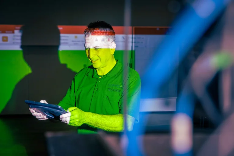 Mit einem iPad richtet Peter Kroy den Beamer für eine anstehende Veranstaltung ein.