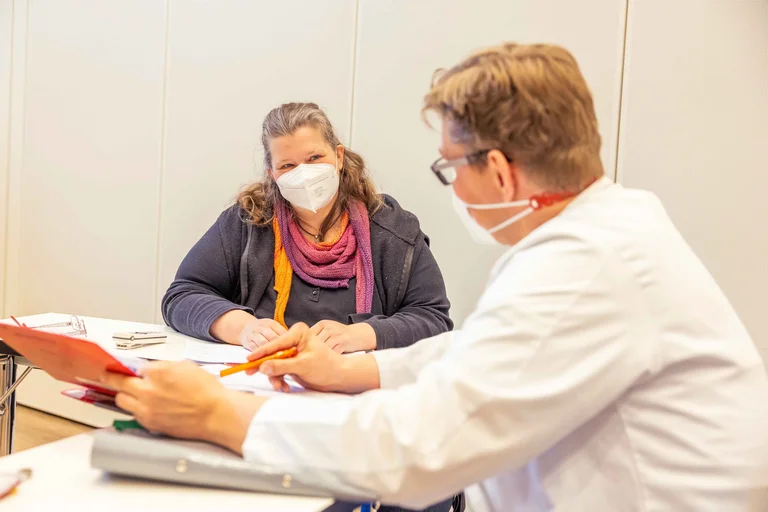 Mit dem Oberarzt bespricht die Kodierfachkaft die Behandlung der Patienten.