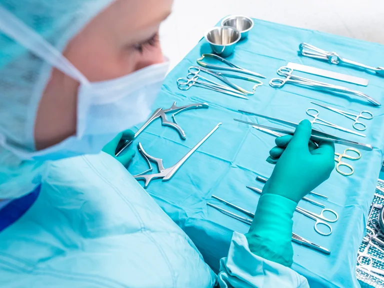 Eine Pflegekraft im Operationsdienst bereitet Instrumente vor