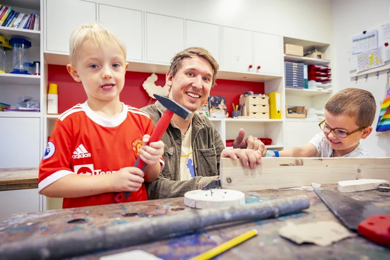 Kinder spielen in einer Gruppe gemeinsam mit einem Erzieher