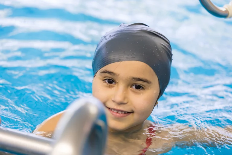 Kind schwimmt im Schwimmbad der Kita