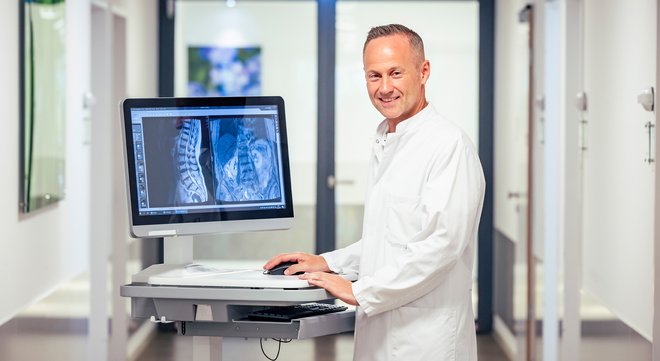 Prof. Dr. Xenofon Baraliakos mit den Bildern einer Patientin