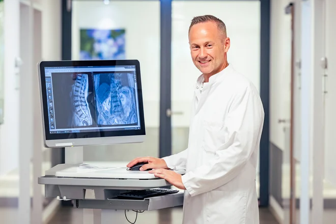 Prof. Dr. Xenofon Baraliakos mit den Bildern einer Patientin