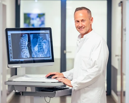 Prof. Dr. Xenofon Baraliakos mit den Bildern einer Patientin