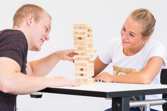 Ausbildung zum Ergotherapeuten: Mit Geschicklichkeitspielen wie hier im Bild mit einem Wackelturm, trainieren Ergotherapeuten Feinmotorik und Geschicklichkeit mit den Patienten.