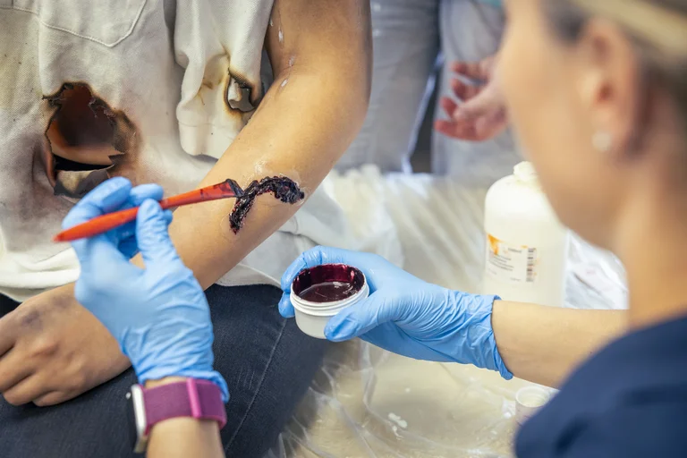 Eine Frau schminkt eine Wunde