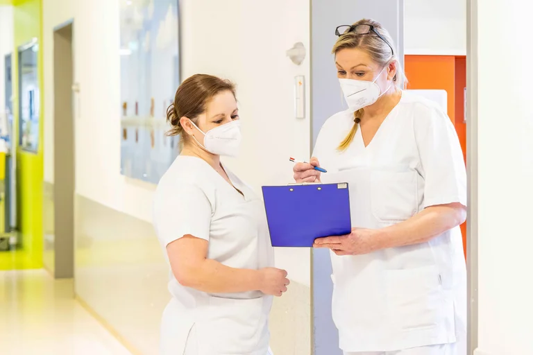 Während ihrer Arbeit ist Nicole Lurz im Austausch mit den Mitarbeitern der St. Elisabeth Gruppe, wie hier mit Janine Kuhn, Stationsleitung, St. Anna Hospital.