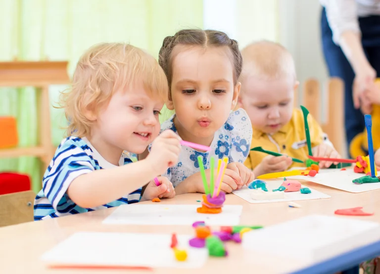 Kinder in der Kita spielen an einem Tisch