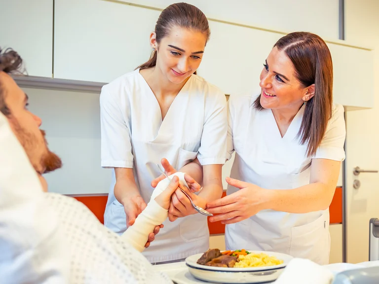 Praxisanleitung Nese Güngor mit einer Auszubildenden am Patientenbett