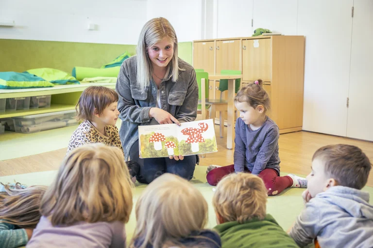 Erzieherin mit Kindern in einer Gruppe